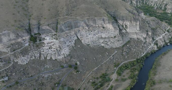 Aerial view of Vardzia cave monastery carved into the Erusheti Mountain, with the Mtkvari River flowing alongside, Gogasheni, Samtskhe-Javakheti, Georgia.