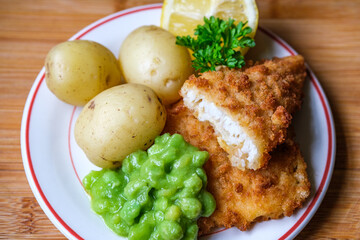 Breaded Cod Fish Fillet With Boiled New Potatoes And Mushy Peas