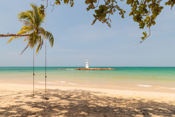 A Lighthouse on the beautiful beach with wooden swing and coconut trees under blue sky in Khao Lak, a destination of tourist in  Phang-Nga province, Southern of Thailand