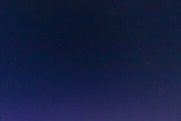 Fototapeta premium A serene night sky filled with countless twinkling stars scattered across deep blue darkness, capturing the quiet beauty of the cosmos.