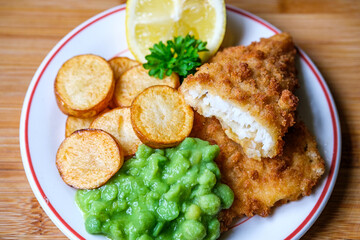 Breaded Cod Fillet With Fried Saute New Potatoes And Mushy Peas