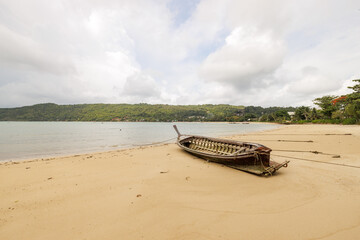 Stranded wooden fishing boat on a beach in southern of Thailand