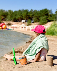 Girl with a shovel and a bucket on the beach.