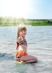 A girl swims in a lake on a sunny day.