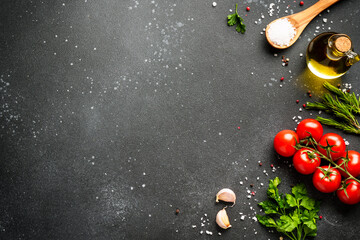 Food background with fresh vegetables, herbs and spices on black.