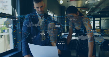 Colleagues reviewing printed report wearing business attire in open office, with world map overlay