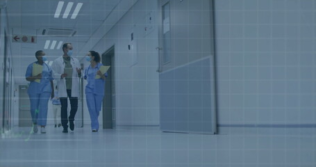 Fototapeta premium Walking masked staff carrying stethoscope tablet folder clipboard in hospital hallway, copy space