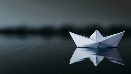 Obraz premium Paper boat floating on still water, conveying simplicity and childhood imagination.