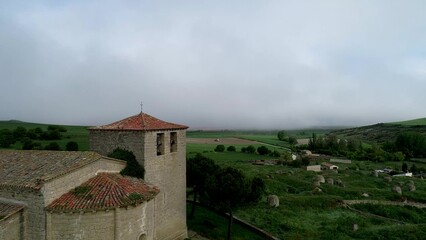 Fototapeta premium Bell tower of Iglesia de San Fructuoso in Valoria del Alcor Palencia under misty sky
