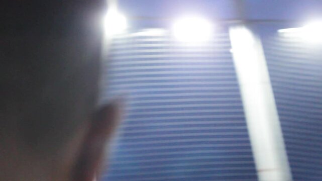 Portrait of a standing Colombian male soccer coach explaining the coaching method to students playing on a synthetic field in Neiva, Huila, Colombia. Concpet of sports