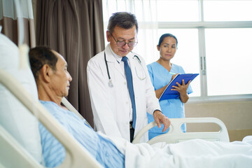 Doctor and nurse visiting elderly patient in recovery room with care.