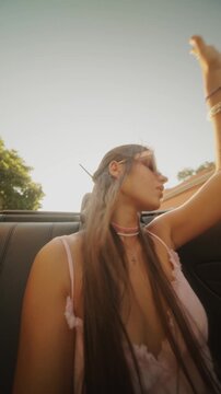 A Carefree Joyride Under the Bright Sun Young Woman Relishing a Fun Convertible Drive