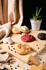 Close-up of thick cookie topped with caramelized speculoos biscuits on rustic wooden board with chocolate chips, ideal for bakery branding, packaging mockup, or menu design.