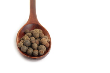 On a white background lies a pile of allspice peas.	