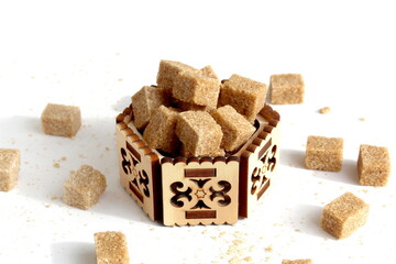 There are a lot of brown sugar cubes in the sugar bowl.