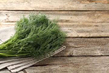 Bunch of fresh dill on wooden table, closeup. Space for text