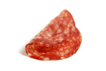 Round pieces of salami lie on a white background.	