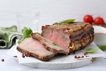 Delicious baked beef meat and spices on light table, closeup