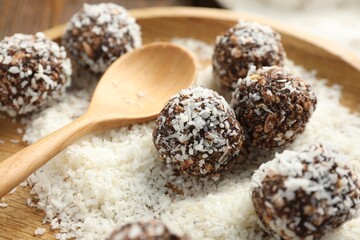 Tasty chocolate candies with nuts and coconut flakes on table, closeup