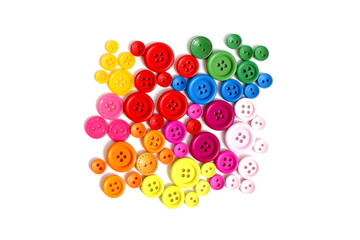 There are many multi-colored buttons on a white background.	