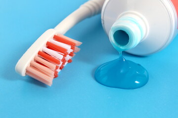 Toothpaste with a brush is on a blue background.	