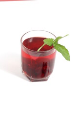 There is a transparent glass with cherry compote on a white background.	