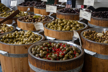 Pickled and marinated black and green olives, artichokes, vegetables on French farmers market, variety of tasty tapas