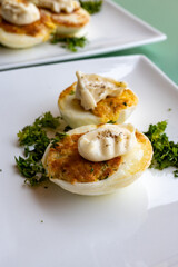French high cuisine starter dish, pan fried chicken eggs with special filling and yellow sauce, vegetarian food in French restaurant