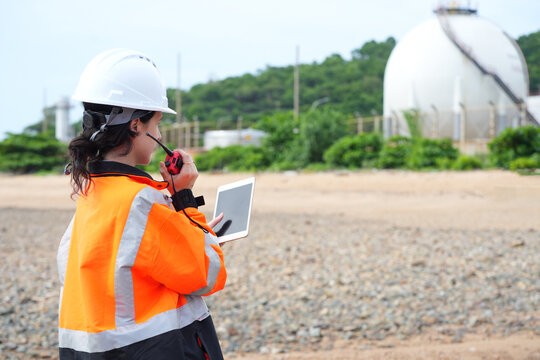 Environmental engineer or ecological scientist industrial worker in safety uniform working for inspect water quality at industry construction site near oil refinery plant by the sea.