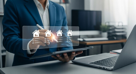 Businessman using a tablet to interact with a holographic display of houses, representing real estate investment or property management