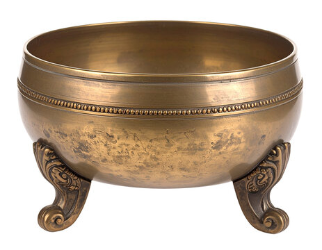 A decorative golden brass bowl on a stand, an antique or ornate object, isolated on a white background.