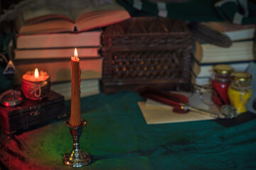 Orange candle on a vintage table, dark academia aesthetic. Evening October time