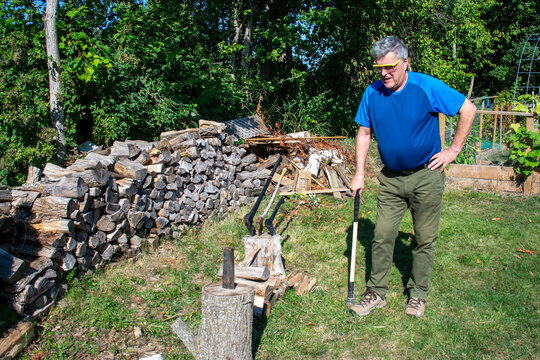man chopping loggs during the day 