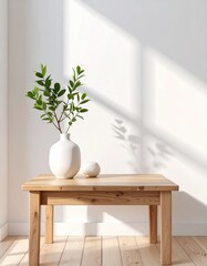 Simple wooden coffee table with a white vase and plants in a bright room. Sunlight casts soft shadows on the wall