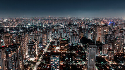 Drone night aerial view of São Paulo residential skyline near Congonhas Airport and Octávio Frias de Oliveira cable-stayed bridge with illuminated high-rise buildings in Brazil