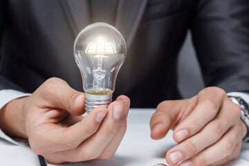 Innovative man holds a light bulb with solar technology.