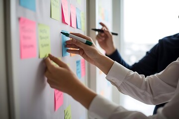 Two individuals collaborating on a project using colorful sticky notes and markers on a whiteboard for brainstorming and planning
