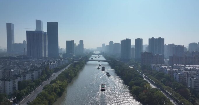 Aerial view of a city canal flanked by modern high-rise buildings under clear sky