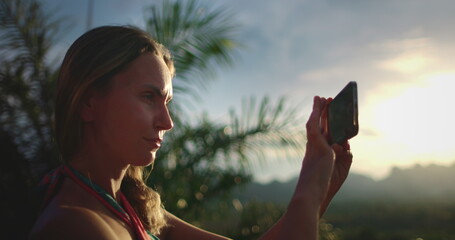 Woman make photo mountain sunset tropical island. Caucasian female tourist portrait hold phone in hands, enjoy outdoor lifestyle travel on summer holiday vacation. Exotic nature landscape. Slow