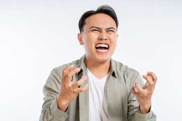 Fototapeta premium A young man is visibly frustrated, showcasing intense emotions in a studio setting.