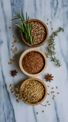 Herbs and grains arranged in wooden bowls on a marble surface in a kitchen setting