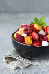  Fresh fruit salad in a black bowl. Healthy natural organic food, low calories delicious dessert. Vegan concept