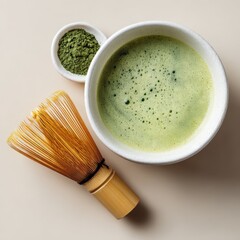 Green matcha tea in a white bowl, accompanied by a bamboo whisk and a small dish of matcha powder, showcasing traditional Japanese tea preparation and presentation