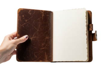 An adult's fair hand with subtle ink stains gently holds open a vintage, distressed deep brown leather journal with a pristine blank page against a white background, concept of creative potential