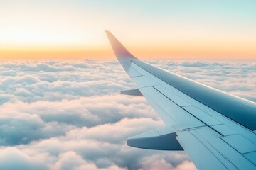 Fototapeta premium Airplane wing flying above fluffy clouds with soft sunlight at sunrise, photographic style, natural sky background, concept of travel and aviation