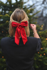 beautiful blond woman in Christmas style, girl is being prepared for the new year. walk at the street with  Christmas tree, smile, take photo