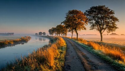 Country road winds through autumnal mist.  Canal reflects sky