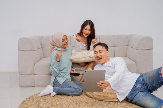 A joyful moment shared among friends enjoying their devices in a comfortable space