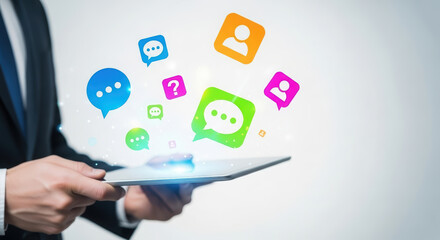 Business professional holding tablet with colorful chat icons floating above, representing digital communication, social media interaction, and modern technology in a corporate environment