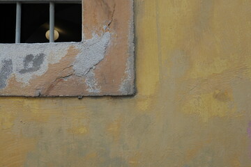 Angle de fenêtre en plâtre peint ocre orangé et mur peint en ocre